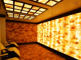 Ariasalt. Large, dimly lit salt room with salt panels on the ceiling