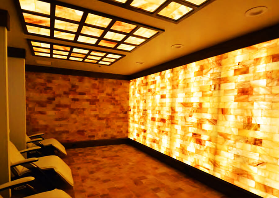 Ariasalt. Large, dimly lit salt room with salt panels on the ceiling