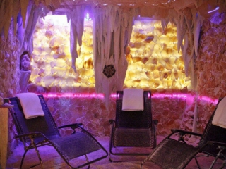 The Saltz Medical Spa. Three Lounge Chairs In Salt Cave. The Cave Is Illuminated By Purple And Pink Lights .