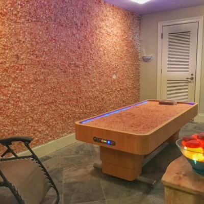 A chair and salt table in a room with a large, pink salt wall at The Club at Admirals Cove in Jupiter, Florida