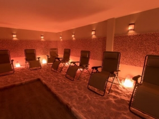 Be Still and Breathe Salt Wellness Center. Large room with 7 lounge chairs wrapping around. Salt on the floor wraps around as well.