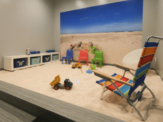 Salt-covered children's playpen with beach wallpaper, beach chair, and toys at the Breathe Salt Vault Springfield, Missouri