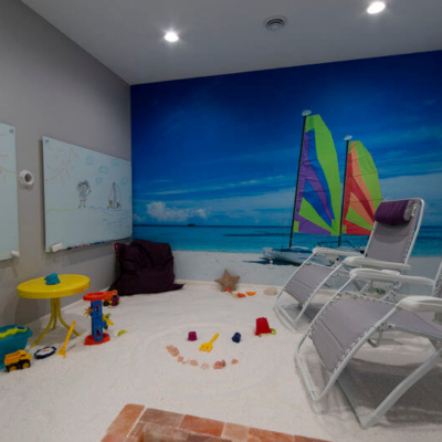Breathe Salt and Sauna. Large open room with beach mural on wall. This room is meant for children as there are toys scattered around the room.