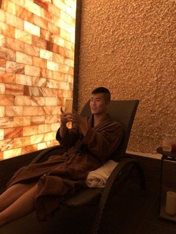 Caesars Entertainment. Man in robe relaxes in lounge chair inside of spa room.