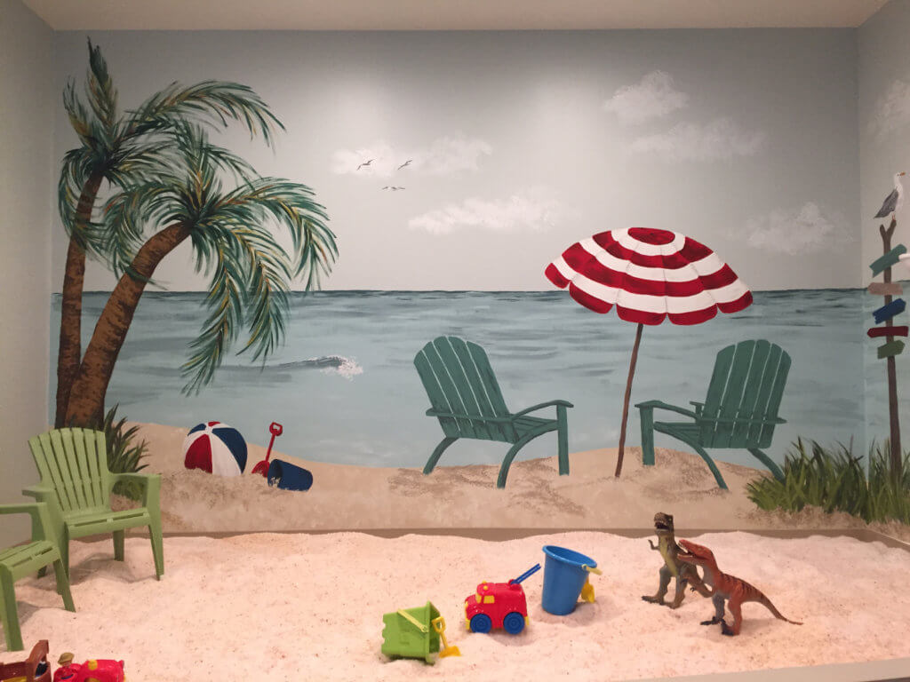 Salt Remedy. Salt room for children with a large beach mural. In the salt are beach toys and beach chairs.