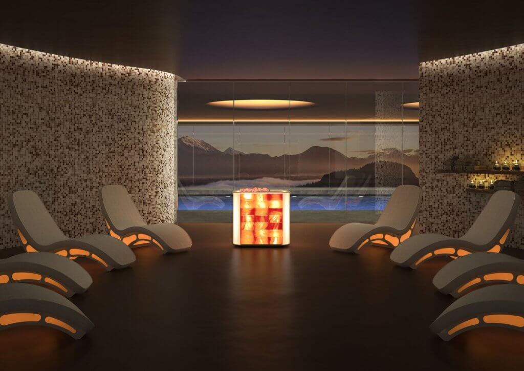 Salt Facility. Large, luxurious spa room with 8 futuristic lounge chairs. A large glass window reveals a pool and mountains in the background.