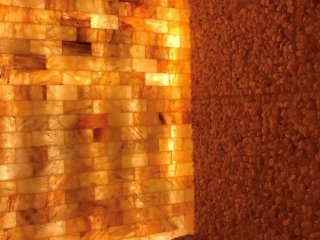 Reflexology By Madalyn. Dimly Lit Salt Room With Salt Tile Wall Illuminating The Room.
