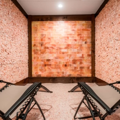 Two Lounge Chairs On A Bed Of Salt Surrounded By Two Himalayan Salt Panel Walls And A Salt Brick Wall At The Intown Salt Room - Atlanta (Grant Park), Georgia.