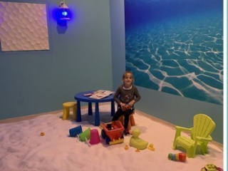 Just Breathe Salt Spa. Inside Salt Room For Children. Large Salt Room With Plenty Of Toys For Children With A Little Boy Playing With Toys.