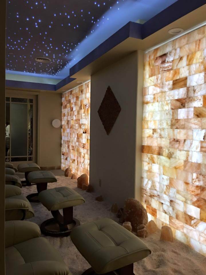Kalahari Resort. Brown lounge chairs in salt room facing tiled wall. The ceiling appears to have scattered blue lights to resemble stars.