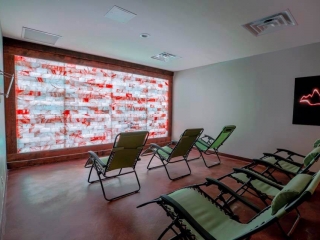 Salt And Spa. 6, Green Lounge Chairs Lined Up Facing A Blue, White And Red Lit Salt Wall.