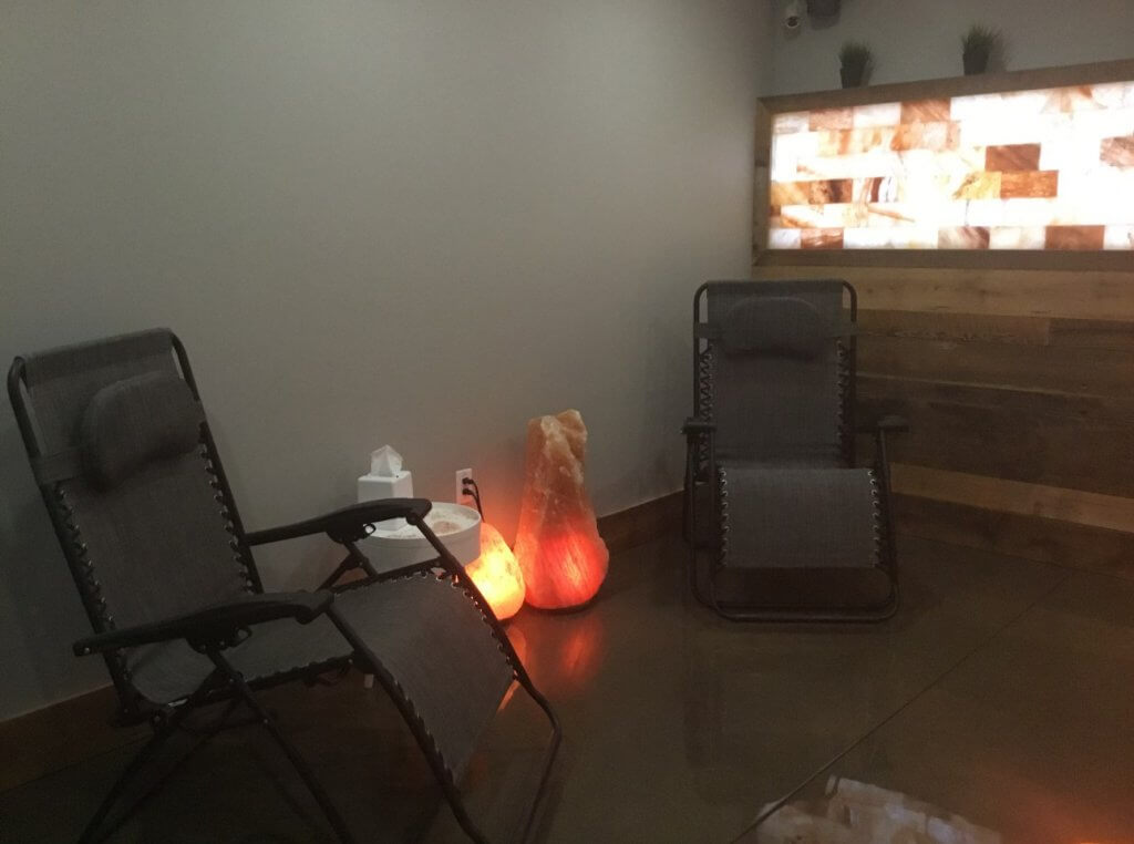 Saltastic. Two lounge chairs in room with 2 glowing salt rocks in between.
