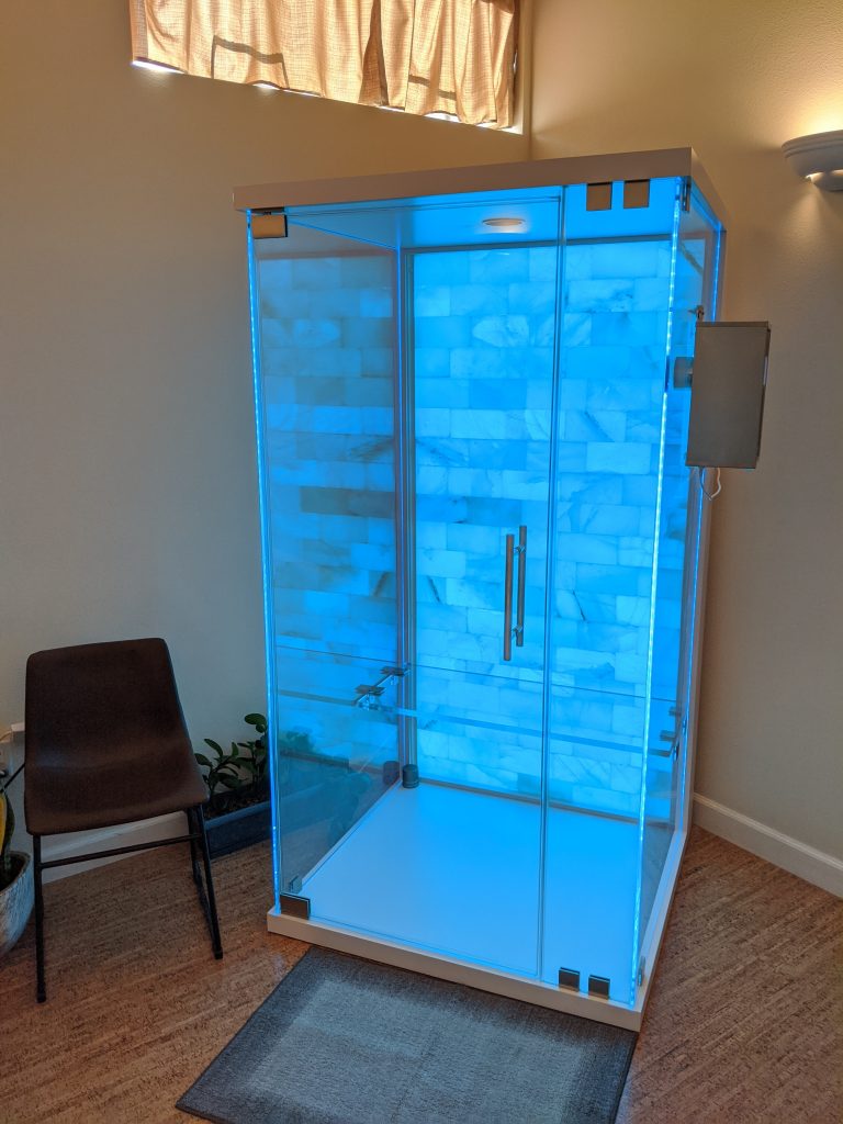 Sloco Massage And Wellness Spa. Glass Salt Chamber Illuminated By A Blue Light.