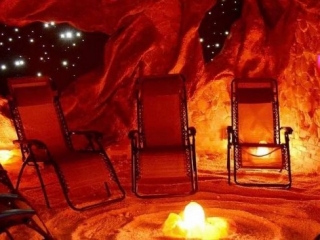Spa Soli. Lounge Chairs Sit On Top Of Salt Floor. Room Is Designed To Have A Cave-Like Feel With A Galaxy Outside.