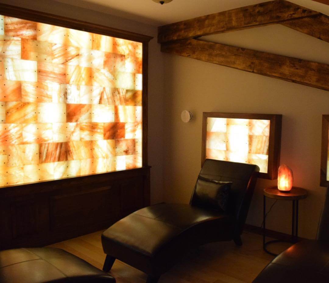 Salt Therapy Room With Three Black Lounge Chairs With Led Backlit Salt Panels At Verbena Holistic Center - Southington, Connecticut.