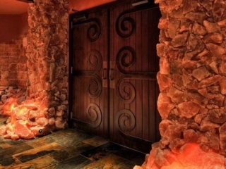 Bien Soigne. Large, medieval, wooden doors surrounded by pink salt rocks.