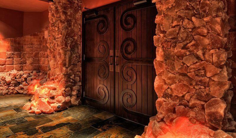Bien Soigne. Large, medieval, wooden doors surrounded by pink salt rocks.