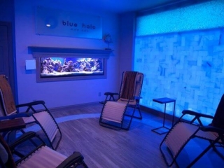 Blue Halo Med Spa. Open room with bright blue wall to the right of the image. Inside the room sits four lounge chairs.