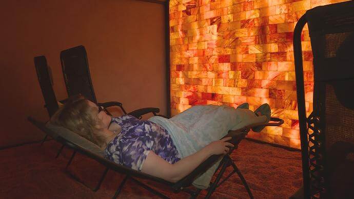 InSpirit Salt Spa. Woman laying back, reclined in a lounge chair in spa room.