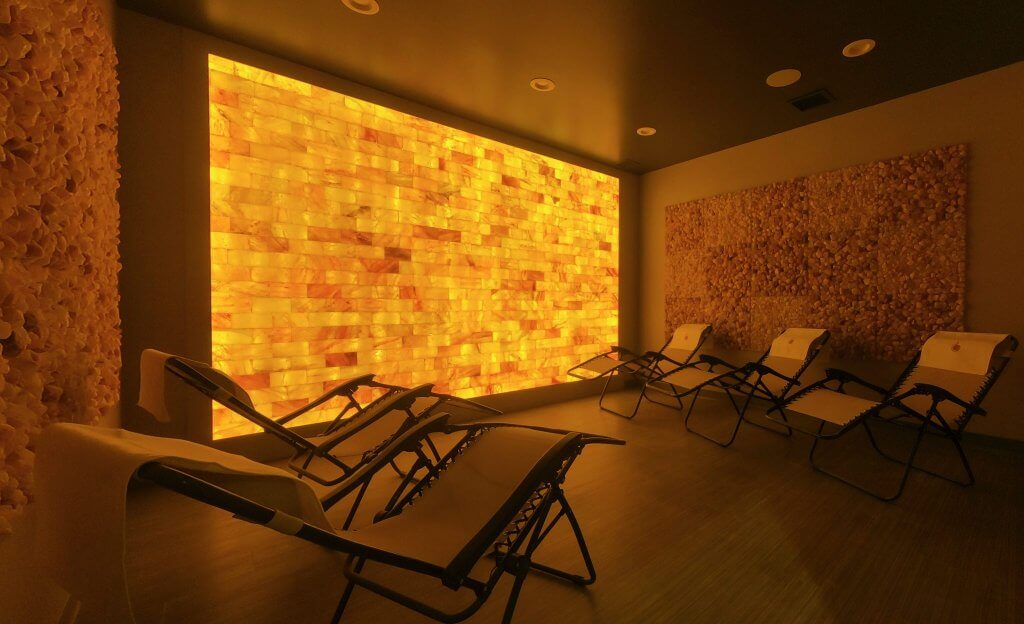 Breathe Salt Vault. Dimly lit spa room full of 5 reclined lounge chairs