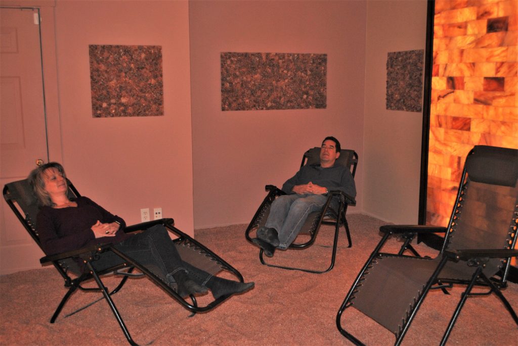 The Salt Works And Spa. Man And Woman Lay Back In Lounge Chairs And Relax In Salt Room.