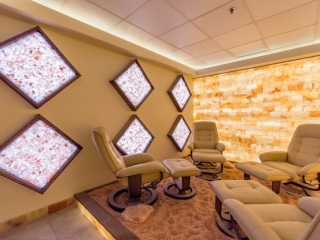 Kalahari Resort. Four Brown Lounge Chairs Facing Each Other Inside Salt Room. 6 Diamond Shaped Salt Decorations Are Mounted On The Wall.