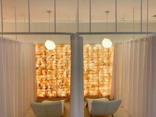 Salt Live Energized. Back View Of Spa Room Facing Empty Chairs Separated By White Curtains In Front Of Salt Wall.