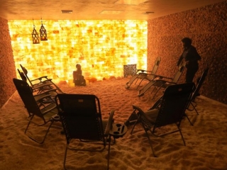Relax Salt Room. 8 Lounge Chairs Circled Up In A Salt Room. One Man Appears To Be Pushing A Lounge Chair.