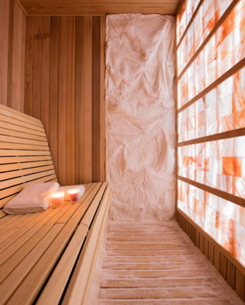 Ohh Yeah Fitness Complex. Small, sauna like, salt room. Candles lit on bench with two towels ready to be used.