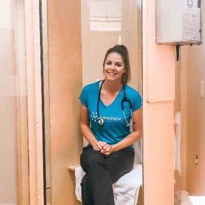 A wooden cryotherapy booth with women sitting and smiling at the Cryomedspa Wellness and Cryotherapy in Durango, Colorado.
