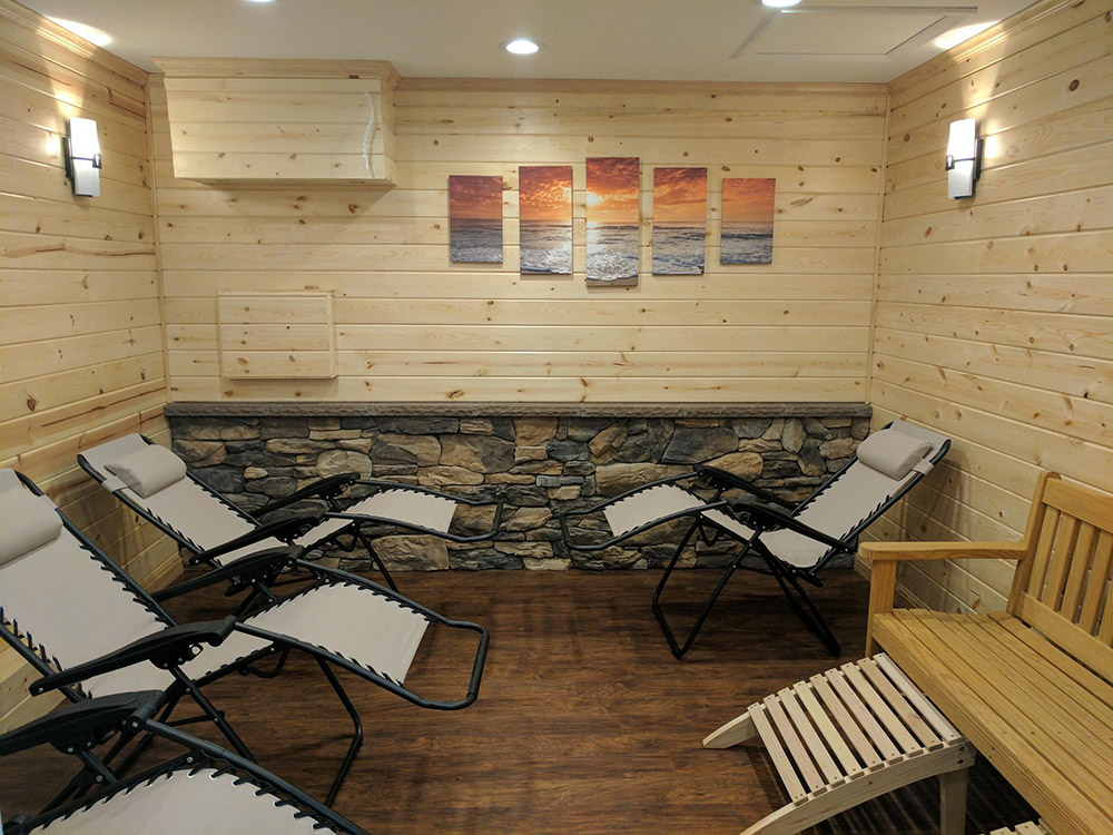 Four lounge chairs and a wooden bench in a wooden room at Salt Haven Therapeutic Salt Room (Fresh Start Chiropractic) in Lock Haven, Pennsylvania
