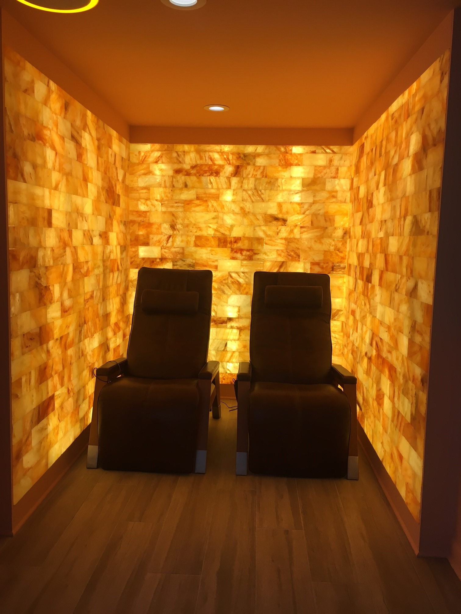 Two Brown Lounge Chairs In A Room Surrounded By Orange Backlit Salt Stone At A Private Home In Arlington, Virginia.