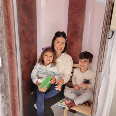 A mother, daughter, and son in an Original SALT Booth for salt therapy at Bay Area Brain Spa in Albany California.