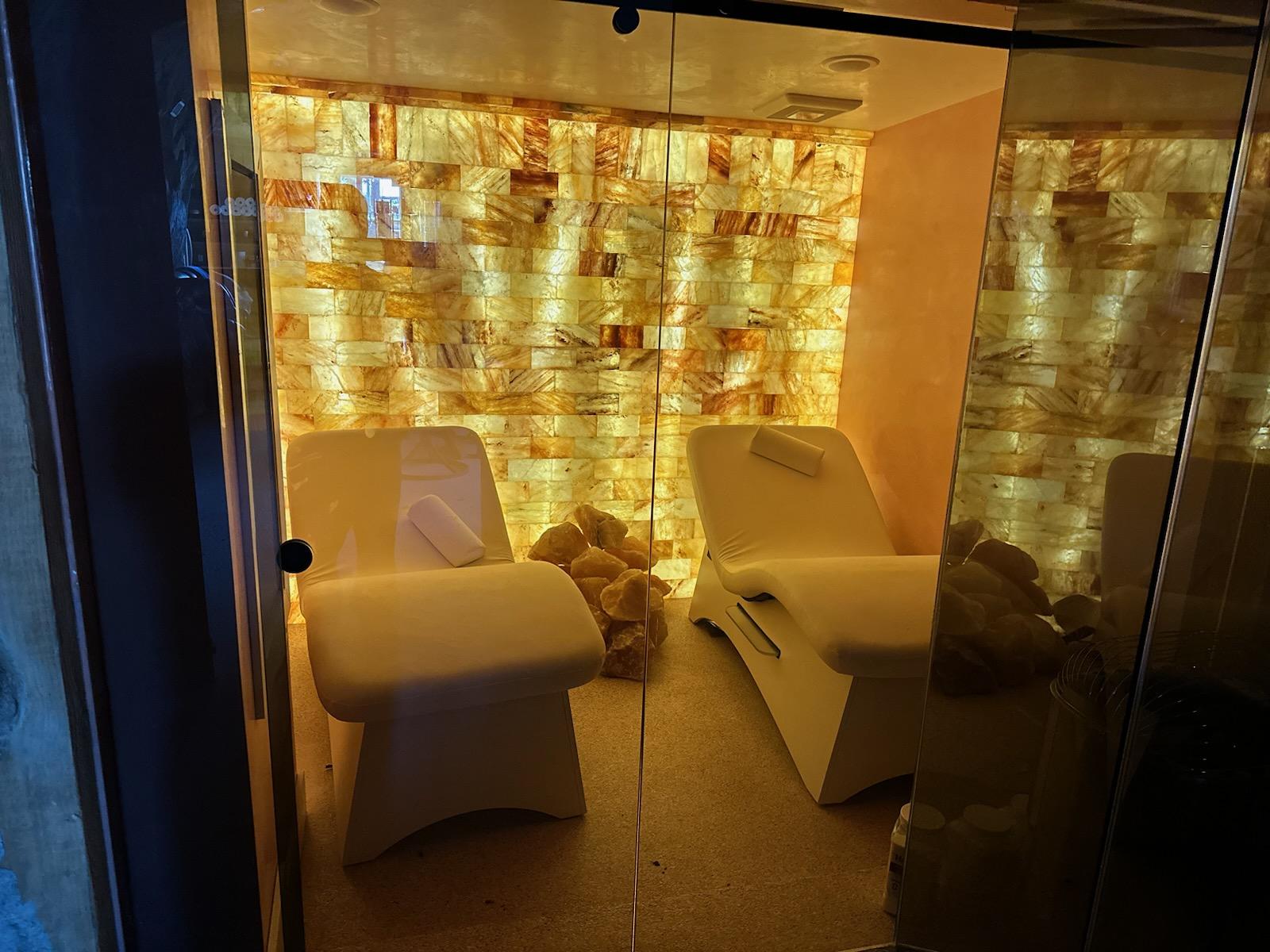 A Salt Room At A Private Home Residence With Two Lounge Chairs And A Himalayan Salt Brick Wall.