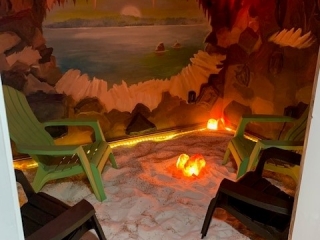 Breast and Body Health Boutique. Cave styled Salt room with green adirondack chairs inside.