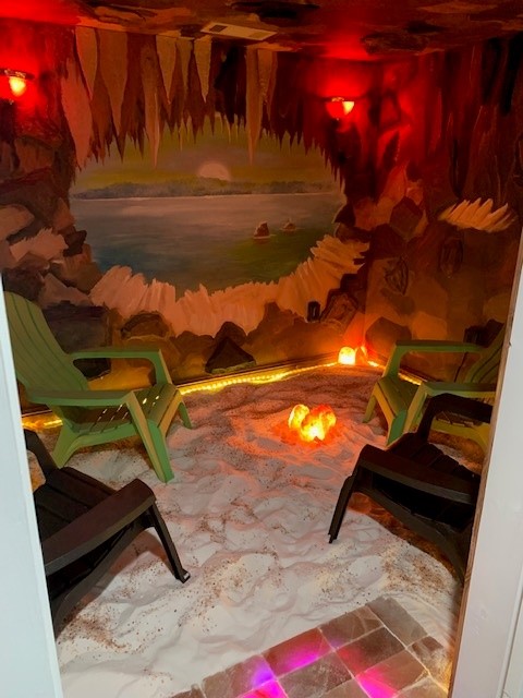 Breast and Body Health Boutique. Cave styled Salt room with green adirondack chairs inside.