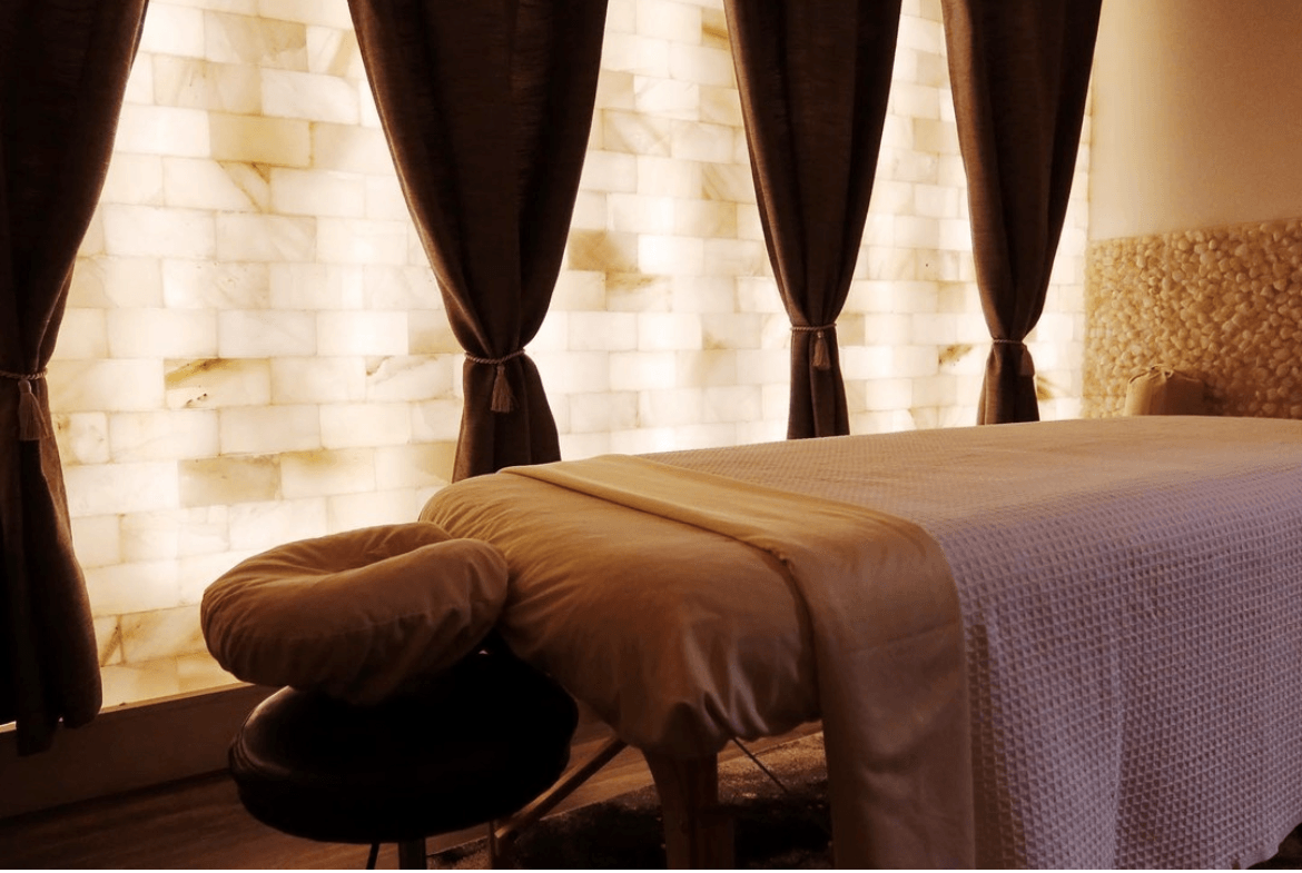 Massage Table With A Himalayan Salt Brick Wall And A Led Backlit Salt Panel Wall At Eleventh Element - Edwardsville, Pennsylvania.