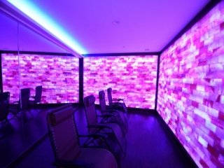 Float Into Wellness And The Salt Lounge &Amp; Sauna Spa. Four Lounge Chairs In Spa Room Lit By Purple Lights,