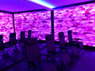 Float Into Wellness And The Salt Lounge &Amp; Sauna Spa. Four Lounge Chairs In Spa Room Lit By Purple Lights,