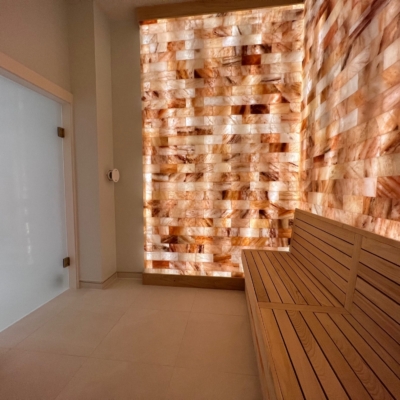 A salt room with a wooden bench and Himalayan salt brick walls at PGA National Resort and Spa in Palm Beach Gardens, Florida.
