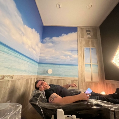 A Man In The Salt Room At Radiant Wellness Infrared Studios In Bargersville, Indiana With Himalayan Salt Panel On The Wall.