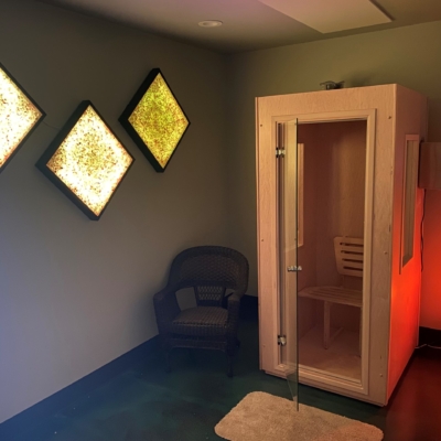 A salt booth with the door open in a room with 3 salt panels hanging from the wall at Sol Health Yoga in Puyallup, Washington.