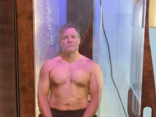 White Man Sitting In A Salt Booth For A Salt Therapy Session.