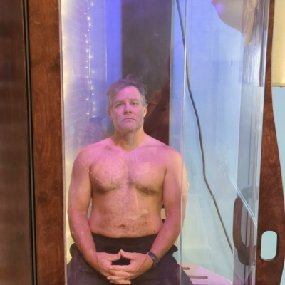White man sitting in a SALT Booth for a salt therapy session.