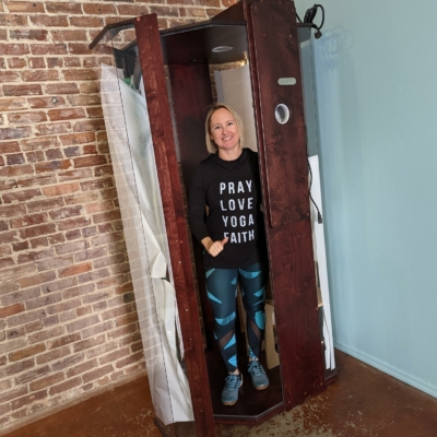 A woman standing in a SALT Booth at Solace Wellness Studio in Boston, Georgia.