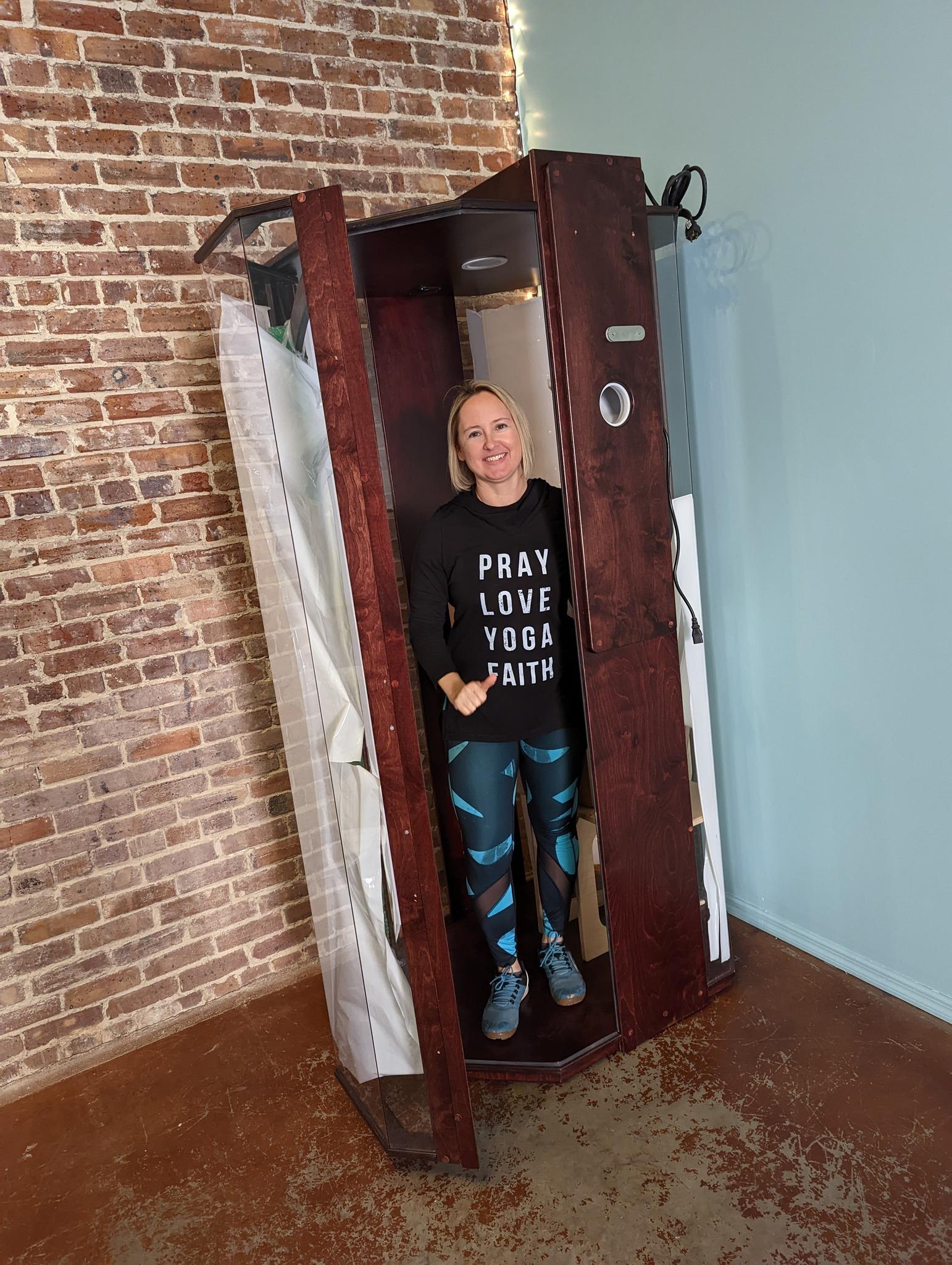 A woman standing in a SALT Booth at Solace Wellness Studio in Boston, Georgia.