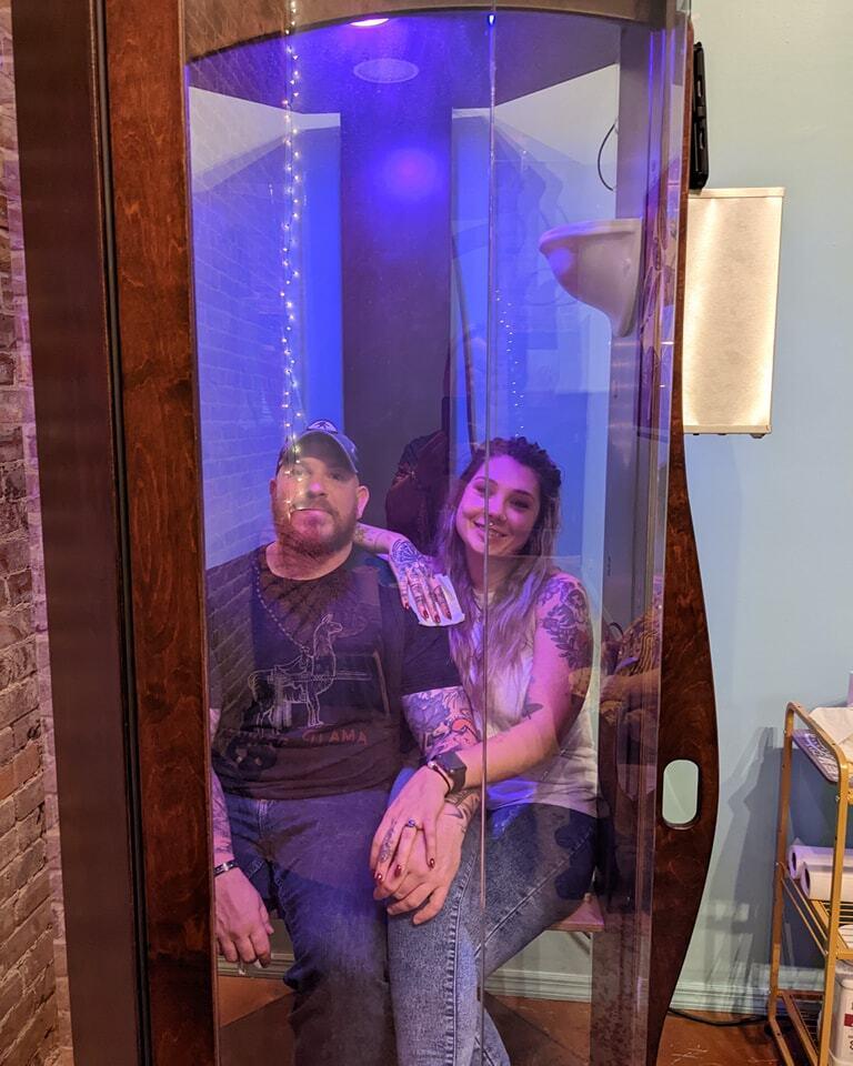 A man and a woman sitting in a SALT Booth for a salt therapy session at Solace Wellness Studio in Boston, Georgia.