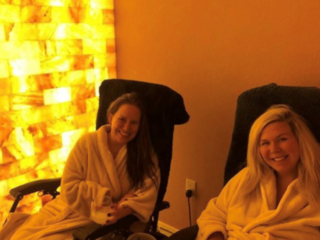 Sweet Be Wellness And Skin Clinic. Two Women In White Robes Sitting In Chairs Smiling Next To Salt Tiled Wall