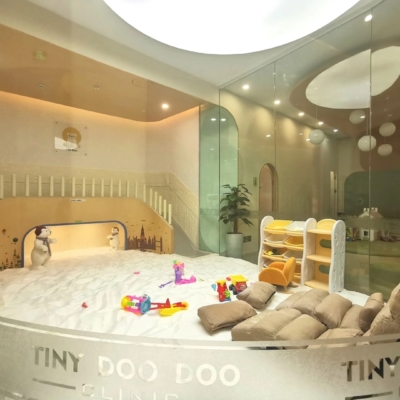 A glass surrounded children's salt room with two tan cushion chairs, a salt-covered floor, and toys at the TSR Bear in Taiyuan, Shanxi, China