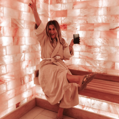 The Salt Room At The Henderson Beach Resort &Amp; Spa In Destin, Florida With A Woman Holding A Drink Sitting On A Bench In Front Of A Himalayan Salt Brick Wall.